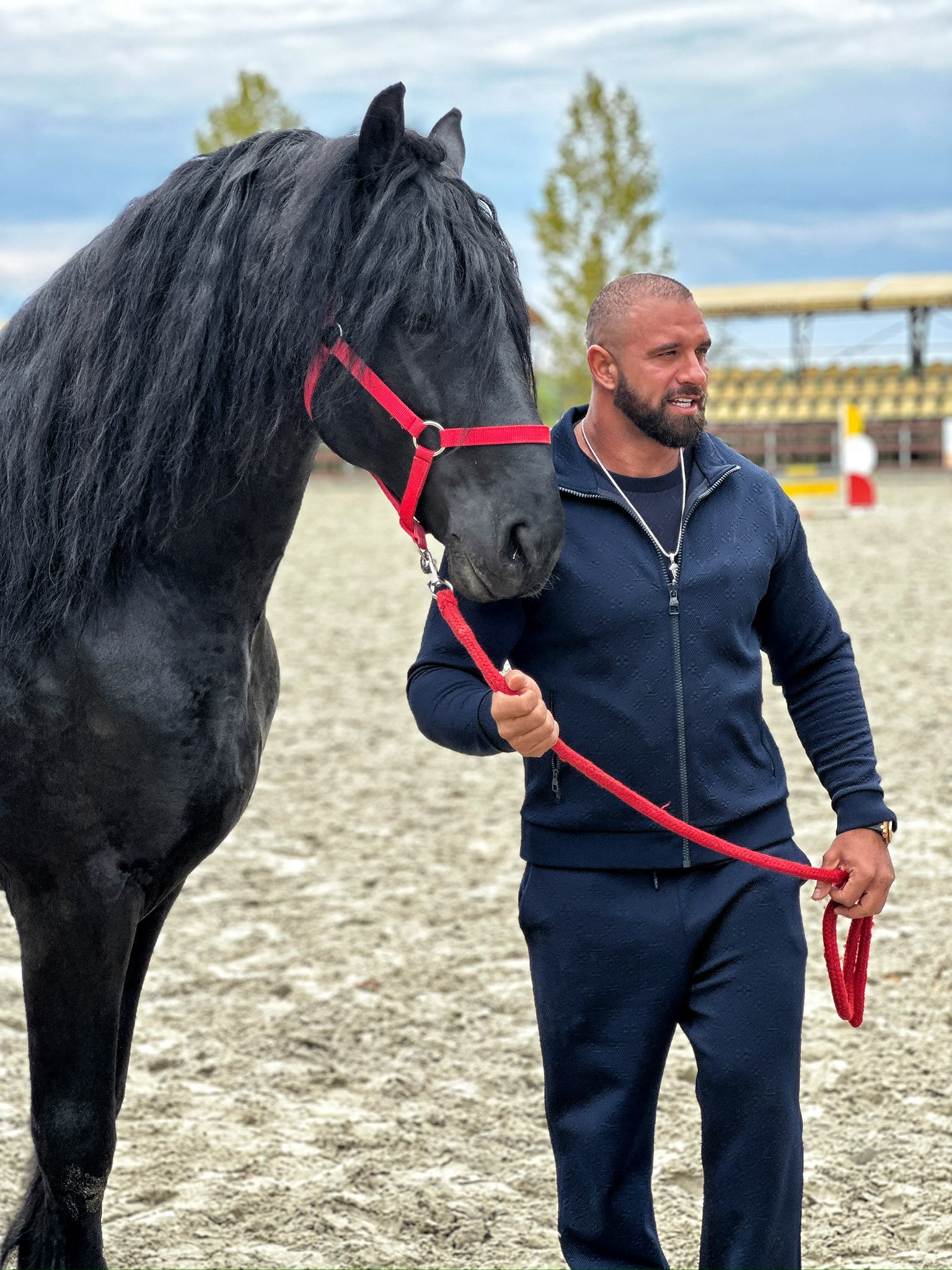 Alex Bodi walking beside a black horse