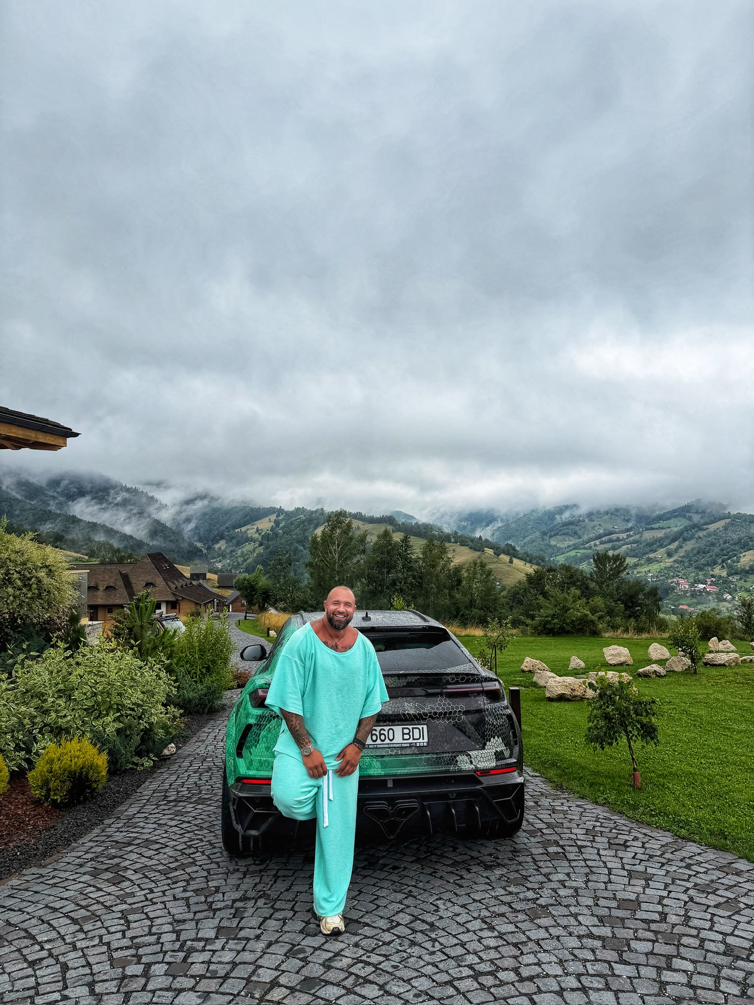 Alex Bodi beside a car in an alpine landscape