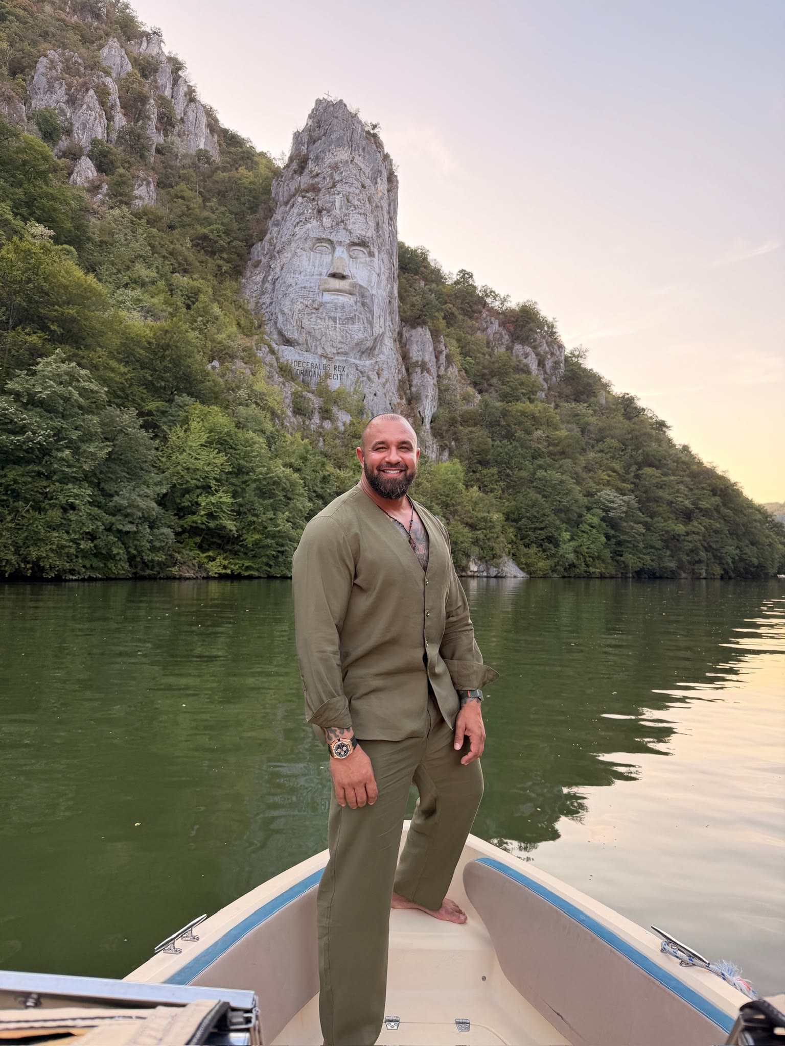 Alex Bodi standing on a boat on a mountain lake